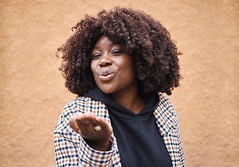 Image showing Smile, flirt and black woman blowing a kiss for love and romance with urban fashion. Girl with hands, lips and kissing air, cute and fun celebration of romantic freedom and flirting with happy youth.