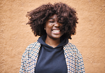 Image showing Black woman, smile and happy young person by an orange wall feeling freedom and joy. Happiness, urban fashion and cool laughing African female smiling with afro hair and stylish clothing outdoor