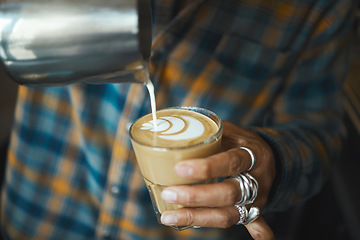 Image showing Latte art, coffee and barista hand with process, workflow and production with drink and working in cafe. Creative, man drawing with milk foam and hospitality with service and beverage closeup