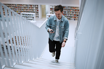 Image showing Staircase, university or man with phone in library for research, communication or blog news. Book, education or happy student on smartphone for scholarship networking, social media or online content