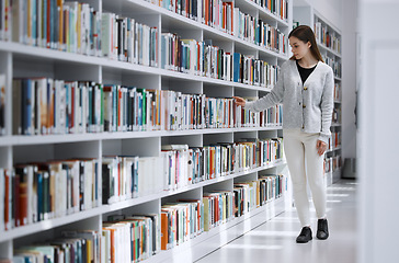 Image showing Woman in library, student search for book and research project, reading with education and learning at university campus. Knowledge, story and fiction with textbook, study and browsing bookshelf