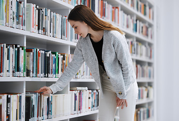 Image showing Woman in library, student with book choice and research project, reading with education and learning at university campus. Knowledge, story and fiction with textbook, study and search bookshelf