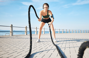 Image showing Fitness, woman and battle rope at the beach for intense arm workout, training or endurance exercise. Active female with ropes in power workout, exercising or focus for muscle bodybuilding outdoors