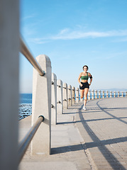 Image showing Fitness, woman and running by the beach side for exercise, training or cardio workout in Cape Town. Active female runner enjoying summer run or exercising for healthy wellness in the nature outdoors