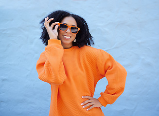 Image showing Trendy portrait, sunglasses and black woman isolated on blue background gen z, youth or fashion clothes. Happy person or beauty model in confidence, vision style and orange color on brick wall mockup