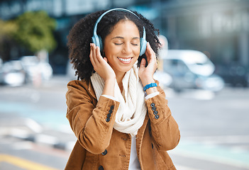 Image showing Music, headphones and black woman happy in city for travel, motivation and mindset. Young person on urban street with buildings background listening and streaming podcast or inspiration audio outdoor