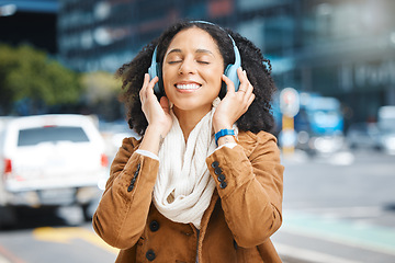 Image showing Black woman with headphones for listening to music in city for travel, motivation and happy mindset. Young person on an urban street with buildings background while streaming podcast or audio outdoor