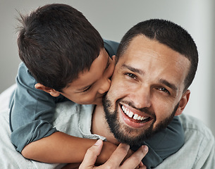 Image showing Love, portrait and kid kissing his father while embracing and relaxing in the living room at family home. Happiness, smile and young man hugging and bonding with boy child with care and in house.