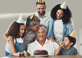 Image showing Family, birthday celebration and senior woman at a table with a cake, love and care in a house. Children, parents and grandparents together for a party to celebrate excited grandma with dessert