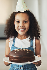 Image showing Happy girl with birthday cake, portrait with child in home and surprise celebration in Atlanta house alone. Young African kid with smile in homemade chocolate dessert, hat on curly hair and excited