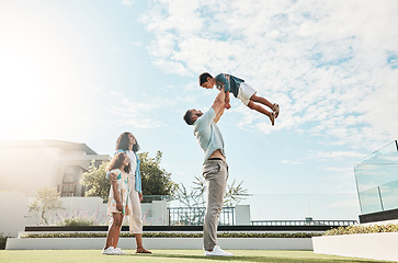 Image showing Family, sky and real estate with a man lifting his son outdoor while bonding as a new homeowner group. Kids, love or summer with parents and children standing outside in the garden of a home property