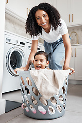 Image showing Portrait of a mother with her kid in a laundry basket at their home while washing clothes together. Happiness, housework and face of young woman having fun with girl kid while cleaning the house.