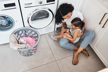 Image showing Mom, girl child and hug by washing machine on floor for cleaning, bonding and care in quality time at house. Laundry, mother and daughter with happiness, love and embrace in family home from top view