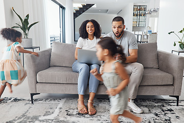 Image showing Black family home, children and running in living room for game, bonding or funny time with parents on sofa. Kids, mother and father on lounge couch with laptop, smile and happiness for love together