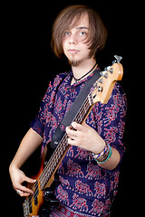 Image showing The young man with a guitar. Isolated on a black