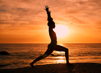 Image showing Fitness, yoga and silhouette of woman at sunrise on beach for exercise, training and pilates workout. Motivation, meditation and shadow of girl balance by ocean for sports, wellness and stretching