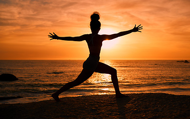 Image showing Meditation, yoga and silhouette of woman on beach at sunrise for exercise, training and pilates workout. Morning, fitness and shadow of girl balance by ocean for sports, body wellness and stretching