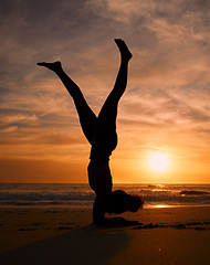 Image showing Yoga woman, silhouette or handstand on sunset beach, ocean or sea in workout or relax exercise training. Yogi, pilates or sand balance pose at sunrise for healthcare wellness fitness or strong body