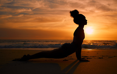 Image showing Sunset yoga, stretching and silhouette of a woman at the beach for mindfulness training at night. Meditation, zen and girl beginning a pilates pose at the sea in the evening for spiritual exercise