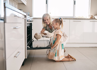 Image showing Kitchen, grandmother and child baking bread together in oven in their modern family home. Happy, smile and girl kid helping senior woman grandma in retirement bake for dinner, party or event at house