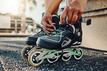 Image showing Hands, fitness and tie roller skates in city to start workout, health and wellness exercise. Sports practice, training and black woman skater tying shoes in street to get ready for skating outdoors.