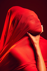 Image showing Model, red fabric and hide face for fashion, aesthetic and beauty with dark studio background. Gen z woman, cloth or silk veil for creativity, vision and art with retro, vintage or creative clothes