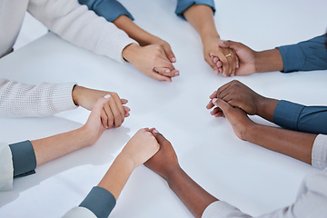 Image showing Business people, holding hands and community in team building, trust or unity together above on table. Hand of group touching in collaboration for mission, support or agreement in solidarity at work