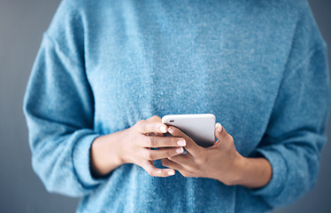 Image showing Phone, hands and woman texting in studio for internet, search or social media on grey background. Online, communication and girl searching on smartphone, website or app while reading isolated closeup