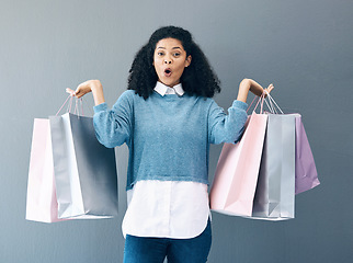 Image showing Wow, sale and portrait of woman with shopping bags, retail therapy and surprise at gift on a wall. Deal, excited and happy girl holding products from a shop, market or mall on a grey background