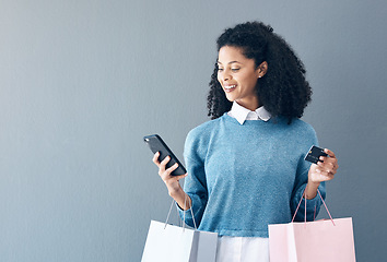 Image showing Mockup, credit card and black woman with smartphone, shopping bags and ecommerce on grey studio background. African American female customer, lady and shopper with cellphone, boutique items or retail