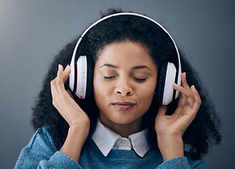 Image showing Headphones, music and face of black woman relax with wall background listening to audio, radio and song. Freedom, calm and happy girl in studio for peace, mindset and streaming wellness podcast