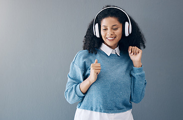 Image showing Music, dance and black woman in studio with freedom, streaming or good mood on grey background. Radio, podcast and girl relax while dancing to audio, online and playlist on advertising isolated space