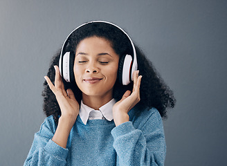 Image showing Relax, music and black woman in studio with peace, streaming or good mood on grey background. Radio, podcast and girl with positive, mindset or audio, online or playlist on advertising isolated space