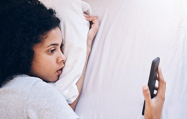 Image showing Phone, depression and woman lying in her bed while watching videos on social media or the internet. Tired, sleepy and depressed female with insomnia networking on a cellphone in her bedroom at home.