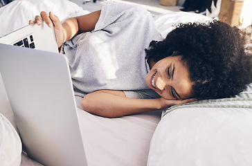 Image showing Laptop, movie and woman watching in bed on the internet while relaxing or resting at her home. Happy, laugh and female streaming an online funny comedy film on a computer while lying in her bedroom.