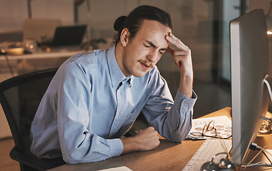 Image showing Man, headache and burnout by computer at night in stress for overworked, anxiety or depression at the office desk. Male employee suffering bad head pain, ache or mental health issues at the workplace