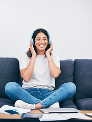 Image showing Music, relax and break with a woman in her home, listening to the radio while sitting on the living room sofa. Peace, wellness or headphones with an attractive young female streaming audio in a house