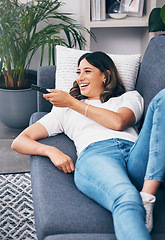 Image showing Watching tv, relax and a woman on a sofa in the living room of her home streaming a subscription service. Television, channel surfing and comedy with an attractive young female lying in her lounge