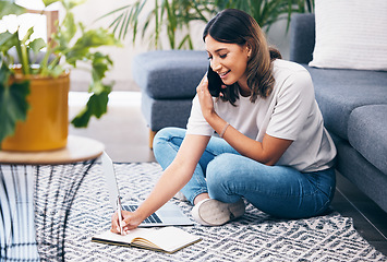 Image showing Woman, phone call and laptop writing notes in the living room by sofa in remote work or studying at home. Female freelancer in conversation or discussion on smartphone, computer and notebook on floor