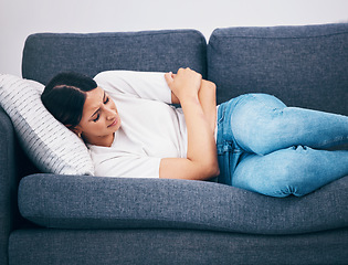 Image showing Sick, menstruation and woman with cramps on the sofa, digestion problem and pain after eating. Healthcare, hungry and girl with constipation, abdomen ulcer and stomachache from a diet on the couch