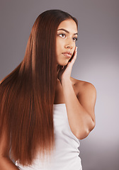 Image showing Woman, long hair and face for skincare, beauty or cosmetics against a gray studio background. Attractive female touching skin in satisfaction for self love or facial, haircare and cosmetic treatment