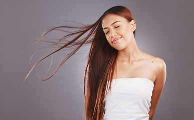 Image showing Salon, hair and hairstyle by woman with care, glow and healthy skincare isolated in a studio gray background. Young, skin and natural beauty model smile due to keratin treatment for haircare