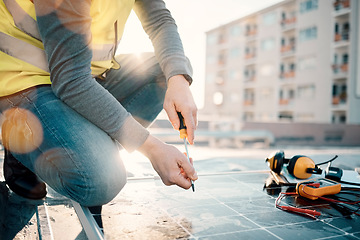 Image showing Hands, solar energy and construction with a man in the city on a rooftop to install a panel for renewable power. Building, grid and electricity with a male handyman or contractor doing maintenance