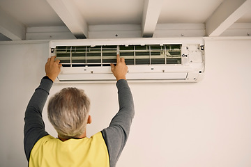 Image showing Construction, installation and back of a man with an air conditioner, maintenance and ac repair. Building, service and a handyman fitting a tool on a wall of a home for home improvement and heat