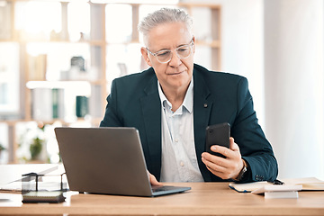 Image showing Laptop, phone and senior business man at desk working online, reading website and internet research. Office, communication and male worker on smartphone for networking, mobile app and social media