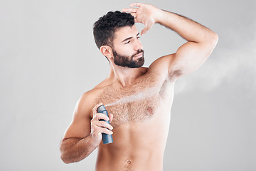 Image showing Spray, deodorant and man with cosmetics, morning routine or grooming on grey studio background. Male, perfume or fragrance for fresh scent, self care or hygiene with guy or antiperspirant on backdrop