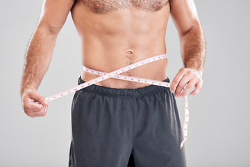 Image showing Fitness, weightloss and man with measuring tape on waist, healthy diet and exercise in body care. Sports, nutrition and stomach, tracking weight loss and six pack progress isolated on grey background