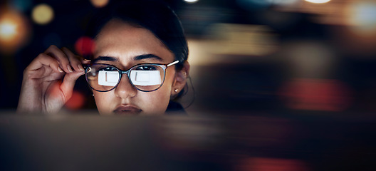 Image showing Woman, glasses reflection and computer at night for planning, website search and technology. Face of female working late on desktop, dark office and reading online network, focus vision and internet