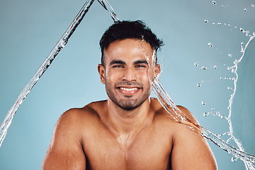 Image showing Water splash, portrait and skincare man isolated on blue background face cleaning, body shower and beauty. Fitness model or person in studio headshot for aesthetic, washing and dermatology hygiene