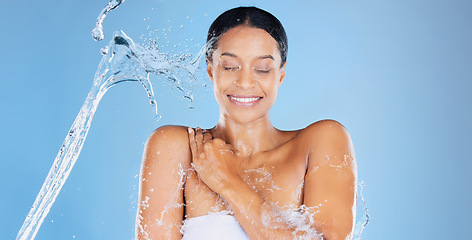 Image showing Happy beauty model, water splash or showering in skincare grooming, healthcare or sustainability cleaning on isolated blue background. Zoom, smile or black woman in wet drops or hydration dermatology